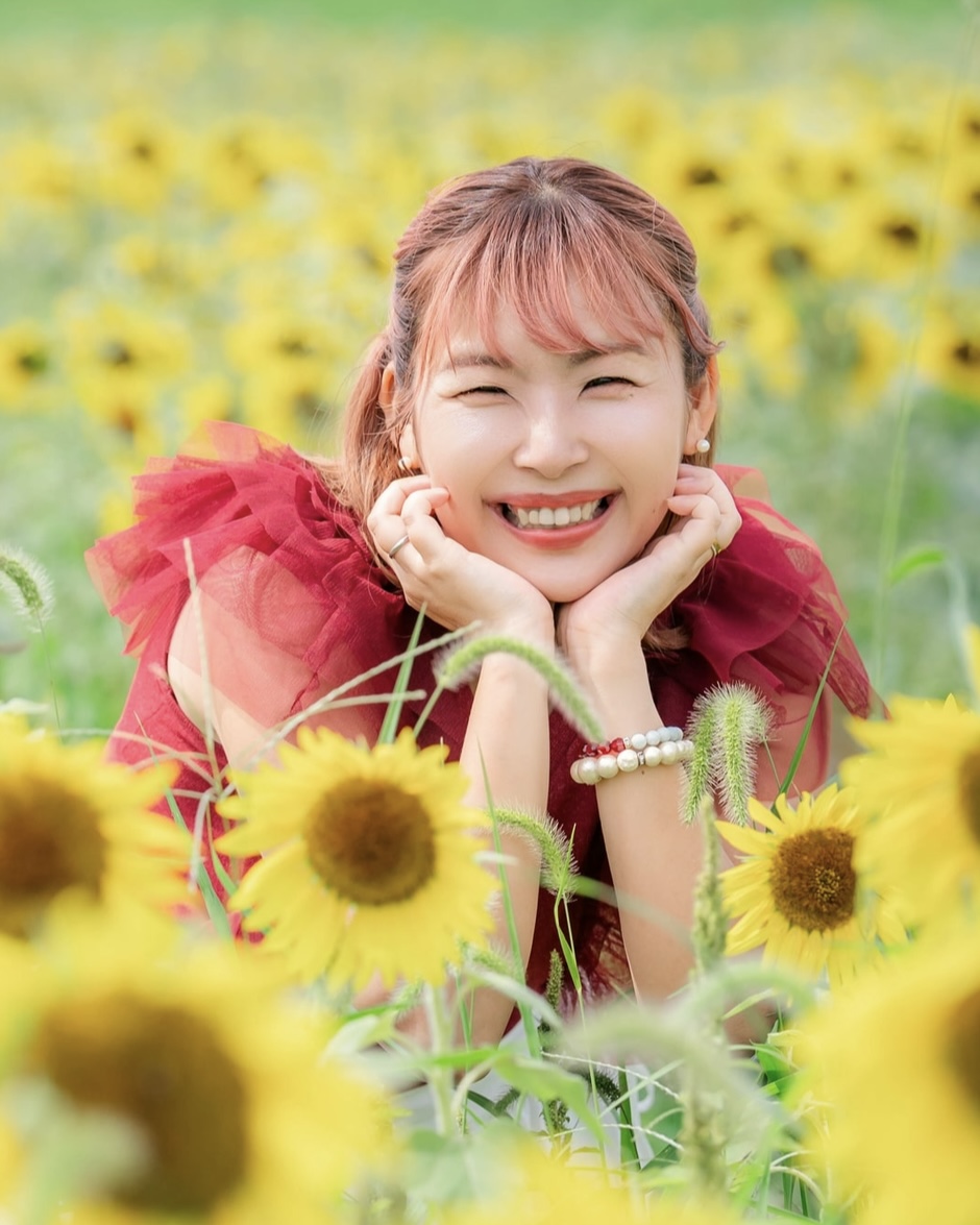 ひまわり畑で両手を頬に添えて笑うみみこ